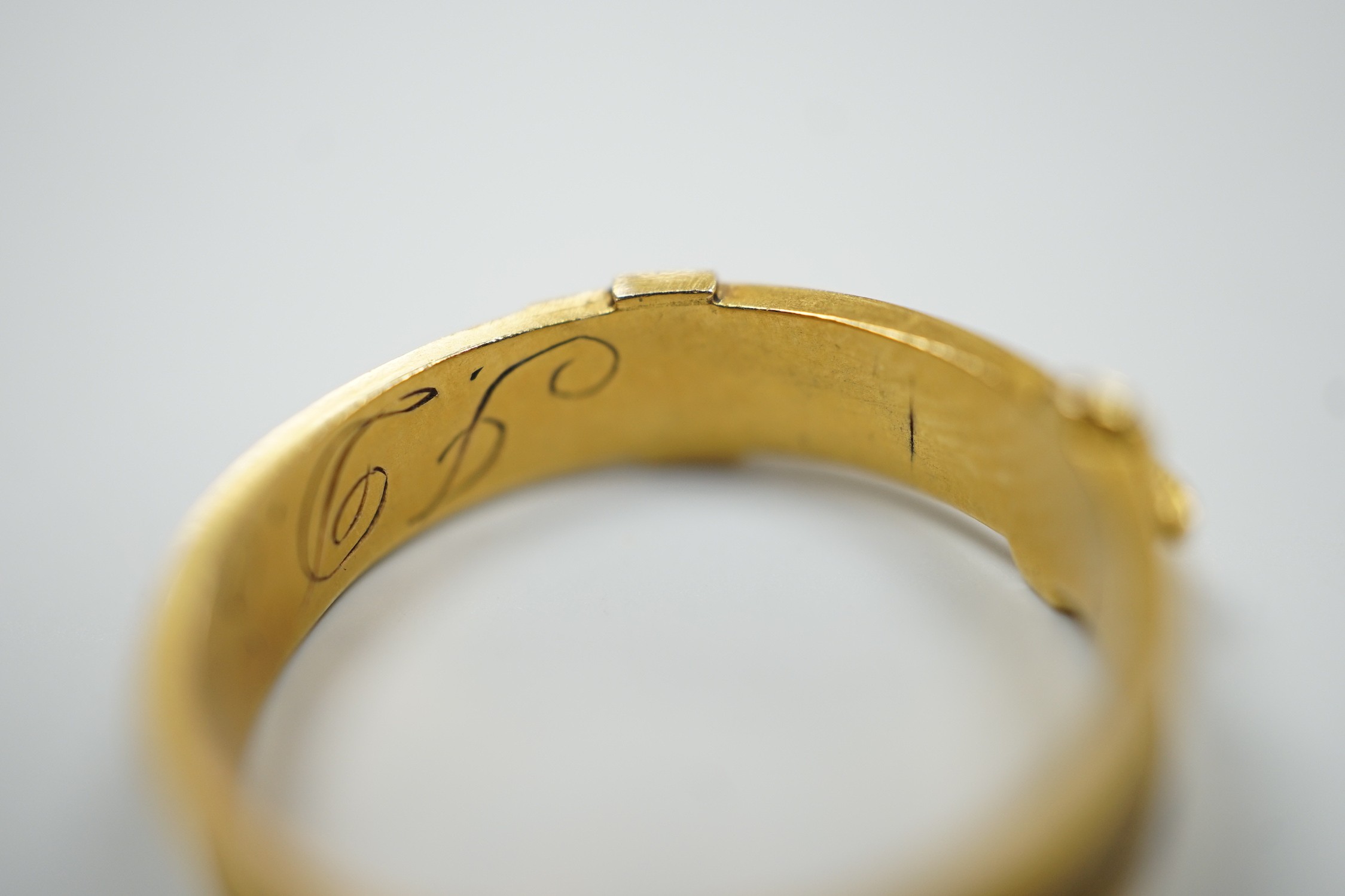 A 19th century yellow metal and plaited hair mourning band, modelled as a buckle, the shank interior engraved with the initials JDS?, size O/P, gross weight 2.1 grams.